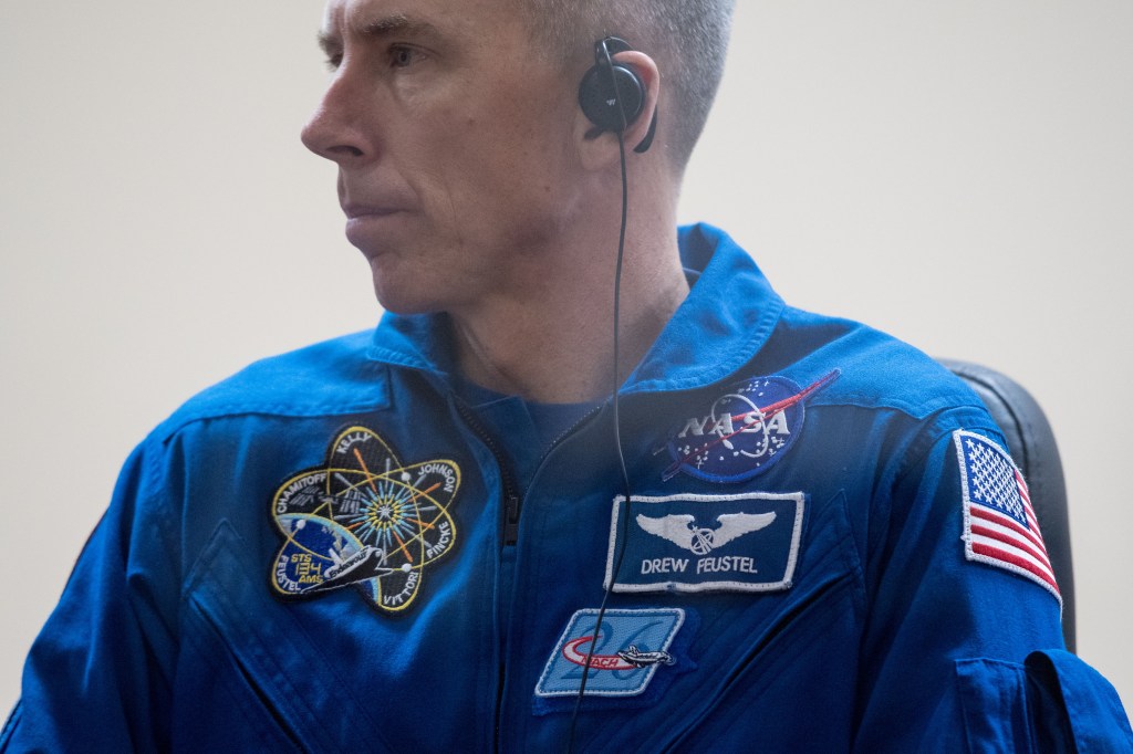 Expedition 55 flight engineer Drew Feustael of NASA is seen in quarantine, behind glass, during a press conference, Tuesday, March 20, 2018 a the Cosmonaut Hotel in Baikonur, Kazakhstan. Feustal, Oleg Artemyev of Roscosmos, and flight engineer Ricky Arnold of NASA are scheduled to launch to the International Space Station aboard the Soyuz MS-08 spacecraft on Wednesday, March 21.