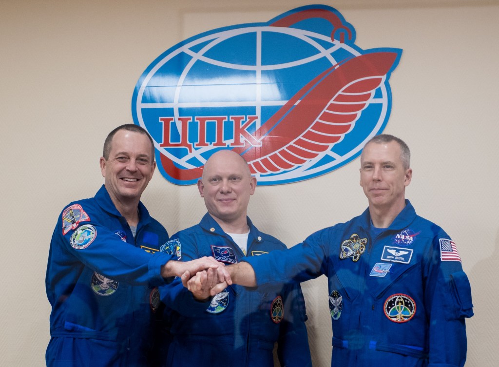 Expedition 55 flight engineer Ricky Arnold of NASA, left, Soyuz Commander Oleg Artemyev of Roscosmos, center, and flight engineer Drew Feustel of NASA, right, pose for a picture at the conclusion of a press conference, Tuesday, March 20, 2018 a the Cosmonaut Hotel in Baikonur, Kazakhstan. Arnold, Artemyev, and Feustel are scheduled to launch to the International Space Station aboard the Soyuz MS-08 spacecraft on Wednesday, March 21.