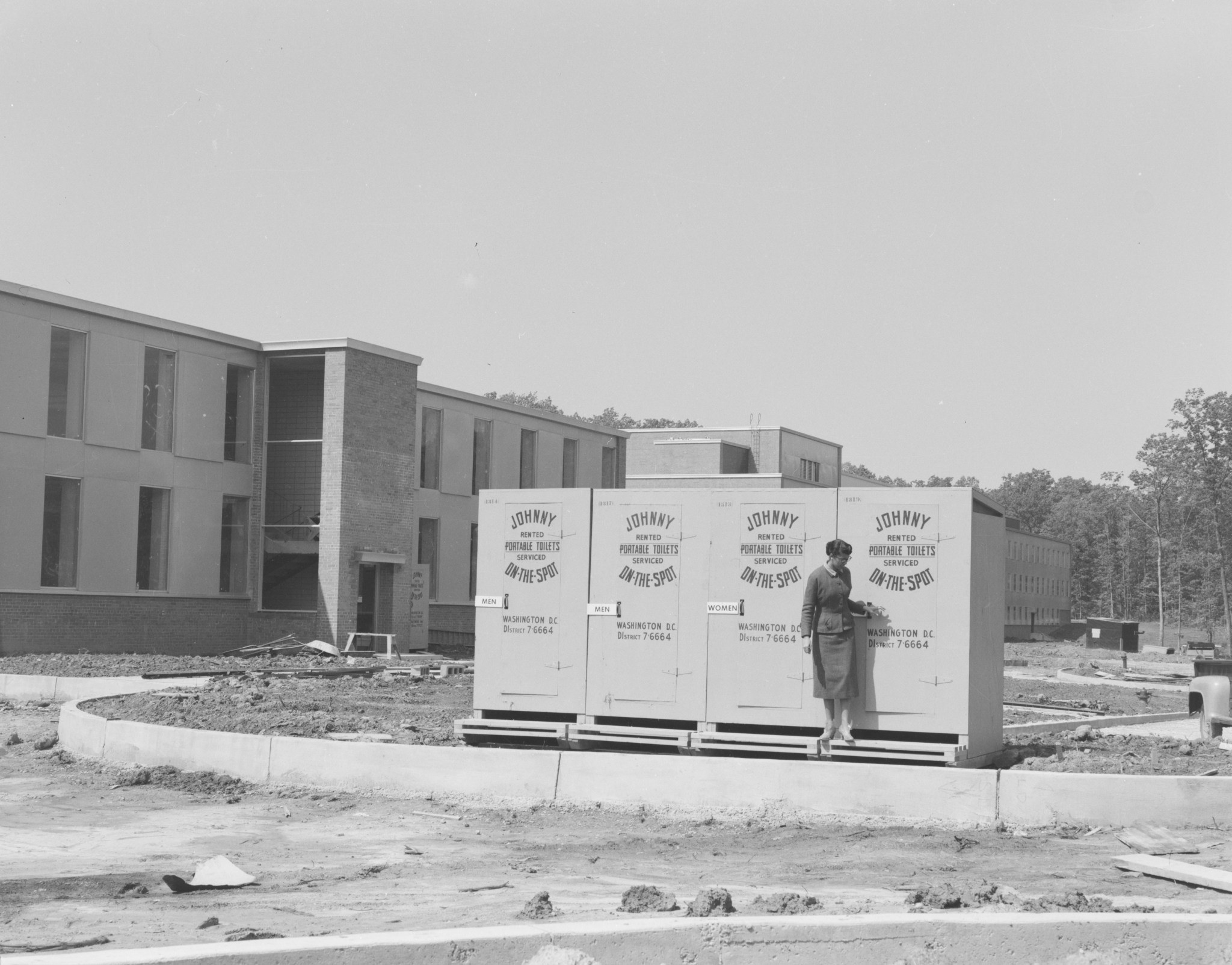 A row of 4 portable toilets outside NASA Goddard's Building 1 circa 1960