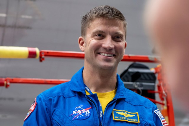 SpaceX Crew-8 Commander Matthew Dominick poses for a photo inside SpaceX Hangar X at the Kennedy Space Center in Florida. Hangar X supports Falcon 9 rocket refurbishment and houses administration offices.