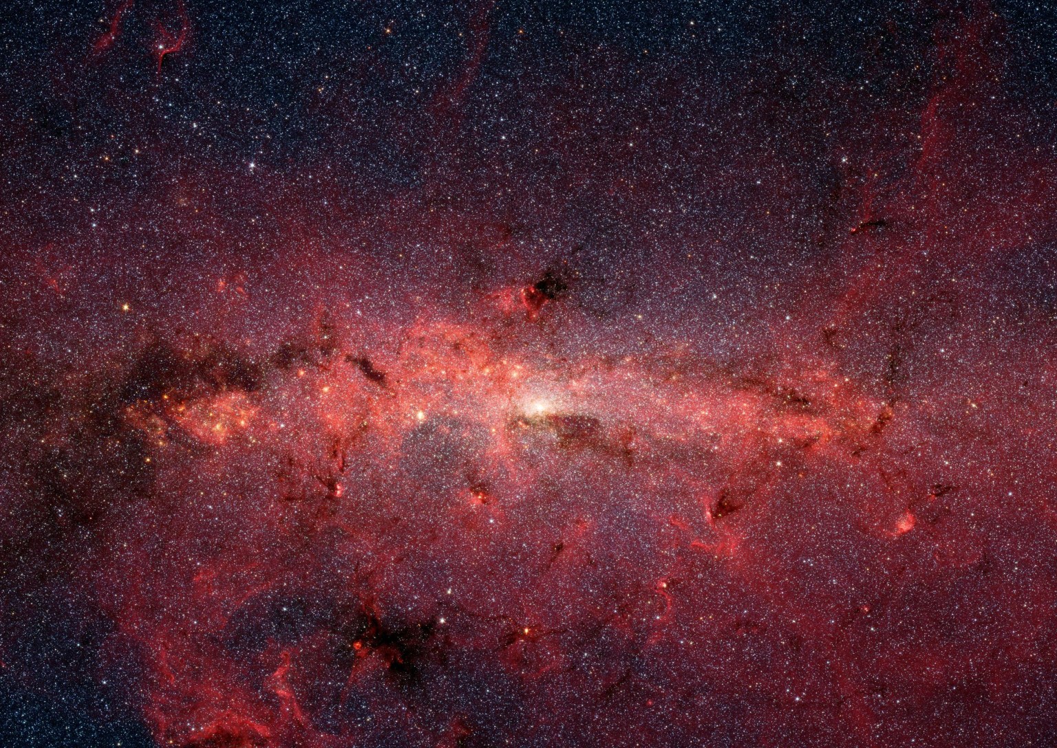 Spitzer Space Telescope's infrared cameras penetrate much of the dust, revealing the stars of the crowded galactic center region of our Milky Way.