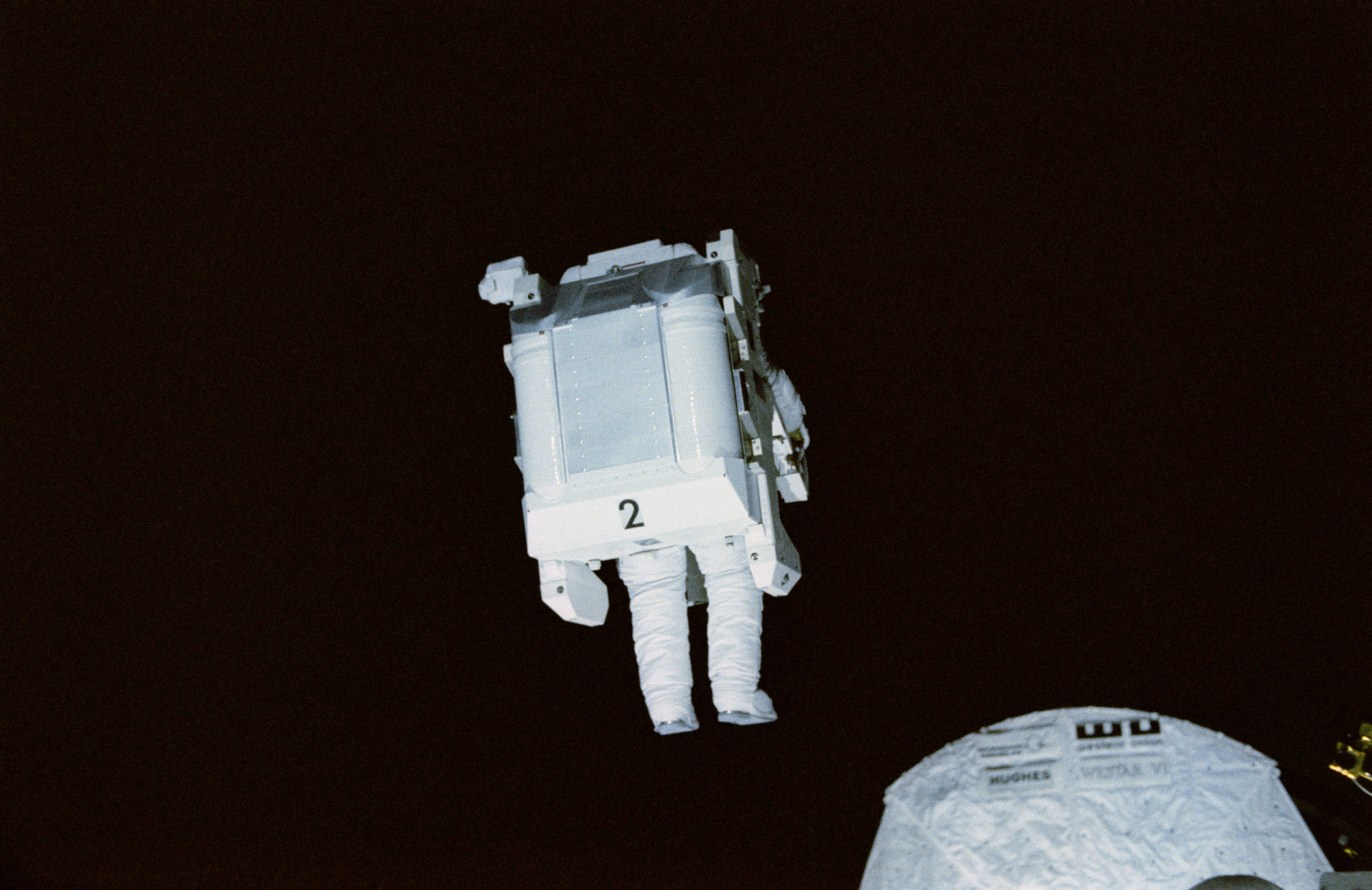 Robert L. Stewart flies the MMU above Challenger’s payload bay