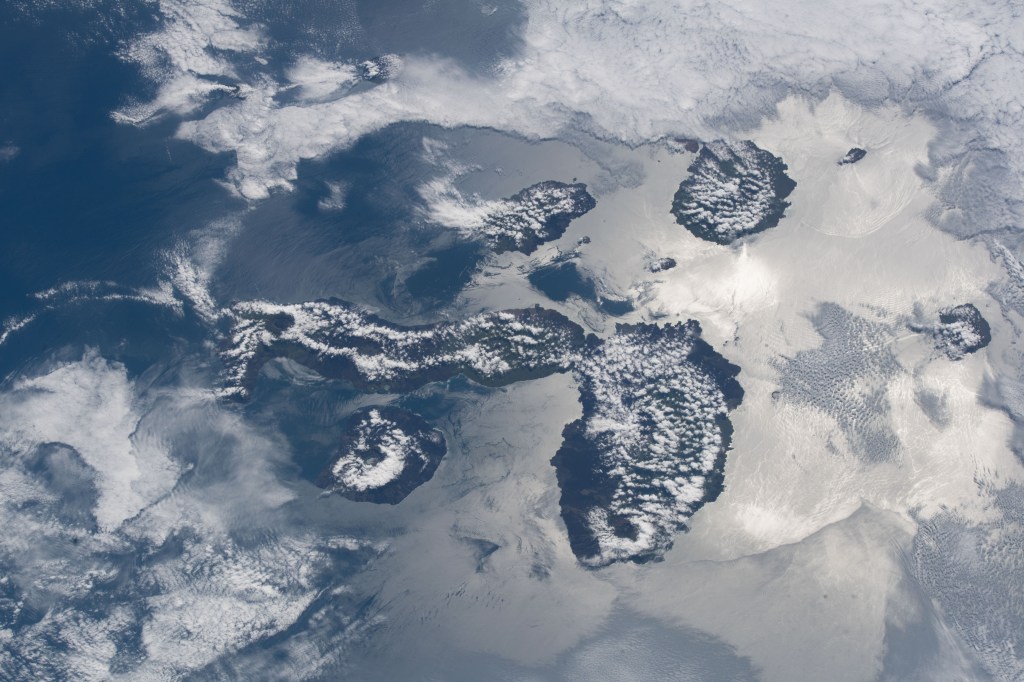 The cloud-covered Galapagos Islands and the sun's glint in the waters off the coast of Ecuador are pictured as the International Space Station orbited above the Pacific Ocean.