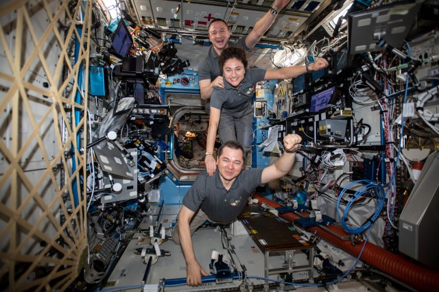 iss062e037614 (Feb. 20, 2020) --- The Expedition 62 crew poses for a playful portrait aboard the International Space Station's U.S. Destiny laboratory module. From top to bottom are, NASA Flight Engineers Andrew Morgan and Jessica Meir and Roscosmos Commander Oleg Skripochka.