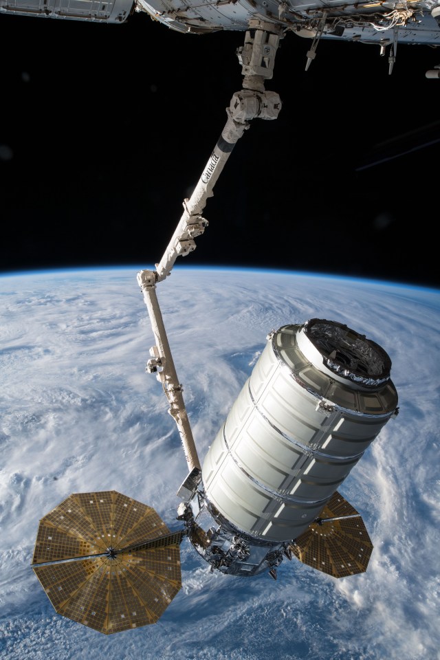The Orbital ATK space freighter is slowly maneuvered by the Canadarm2 robotic arm toward the Unity module for installation on the International Space Station to resupply the Expedition 55 crew.