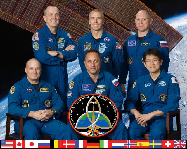 The six-member Expedition 55 crew poses for an official crew portrait at the Johnson Space Center in Houston, Texas. In the front row (from left) are Scott Tingle of NASA, Commander Anton Shkaplerov of Roscosmos and Norishige Kanai of the Japan Aerospace Exploration Agency. In the back row (from left) are NASA astronauts Ricky Arnold and Andrew Feustel and Roscosmos cosmonaut Oleg Artemyev.