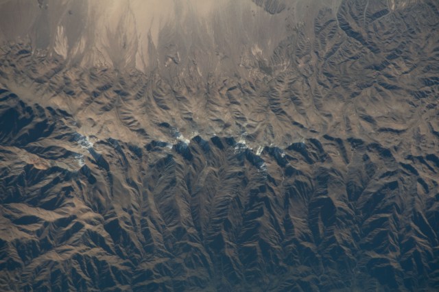 The snow-capped tips of the Andes Mountains range separates the South American countries of Chile and Argentina.