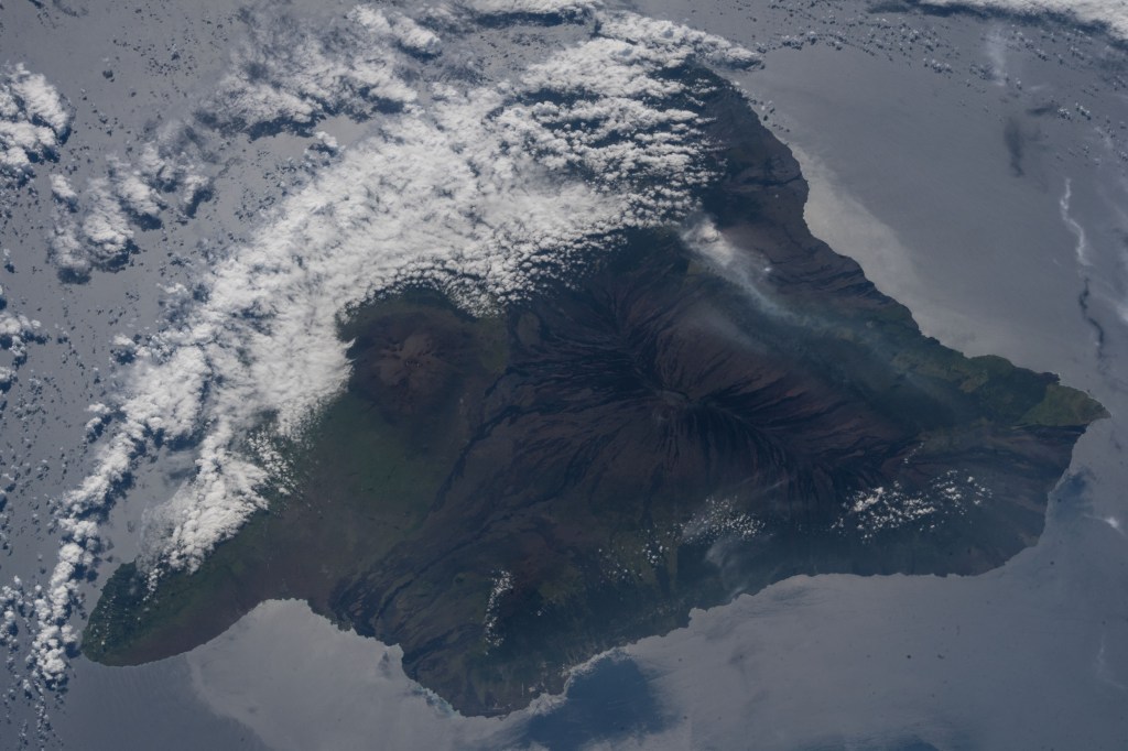 The volcanic ash plume from Mount Kilauea is seen just inland off the eastern coast of Hawaii's Big Island.