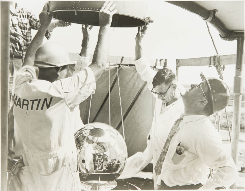 The shiny sphere-shaped Vanguard II satellite is prepared for launch in 1959.