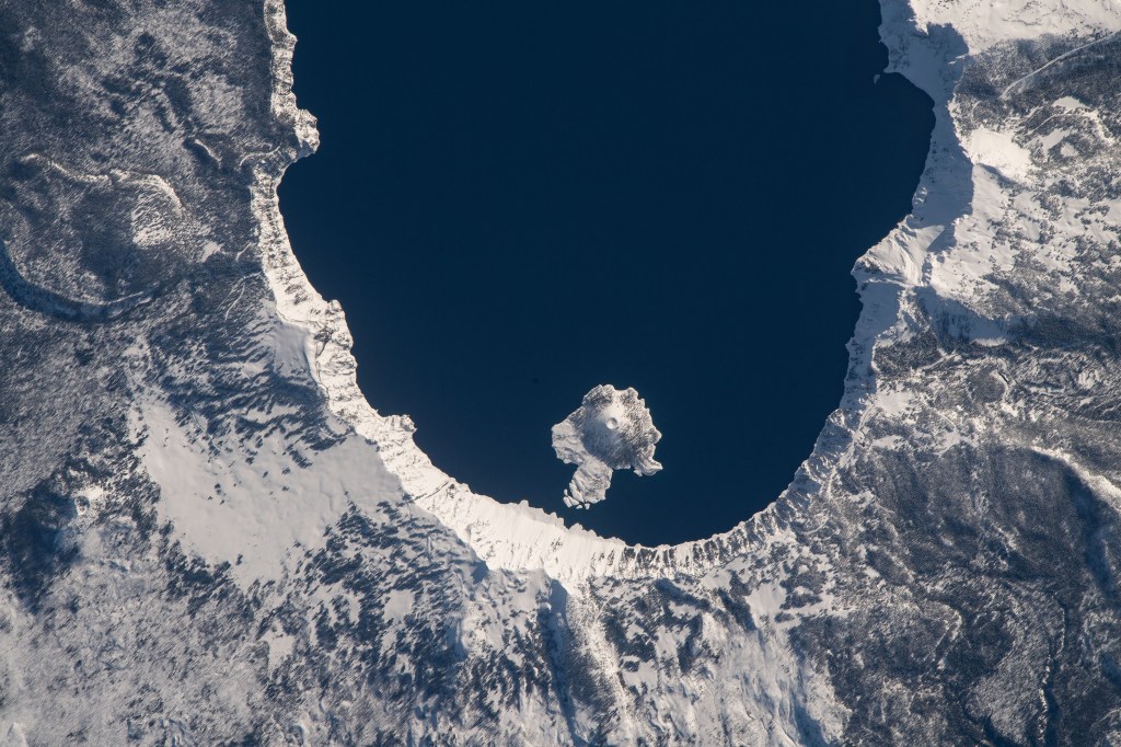 iss070e099660 (Feb. 23, 2024) -- A snow-covered Crater Lake National Park is visible from the International Space Station as it orbits 261 miles above Oregon. The park sees snow most of the year, which feeds into the lake, crowned the deepest in the United States. Near the west end of the lake is Wizard Island, a volcanic cinder cone.