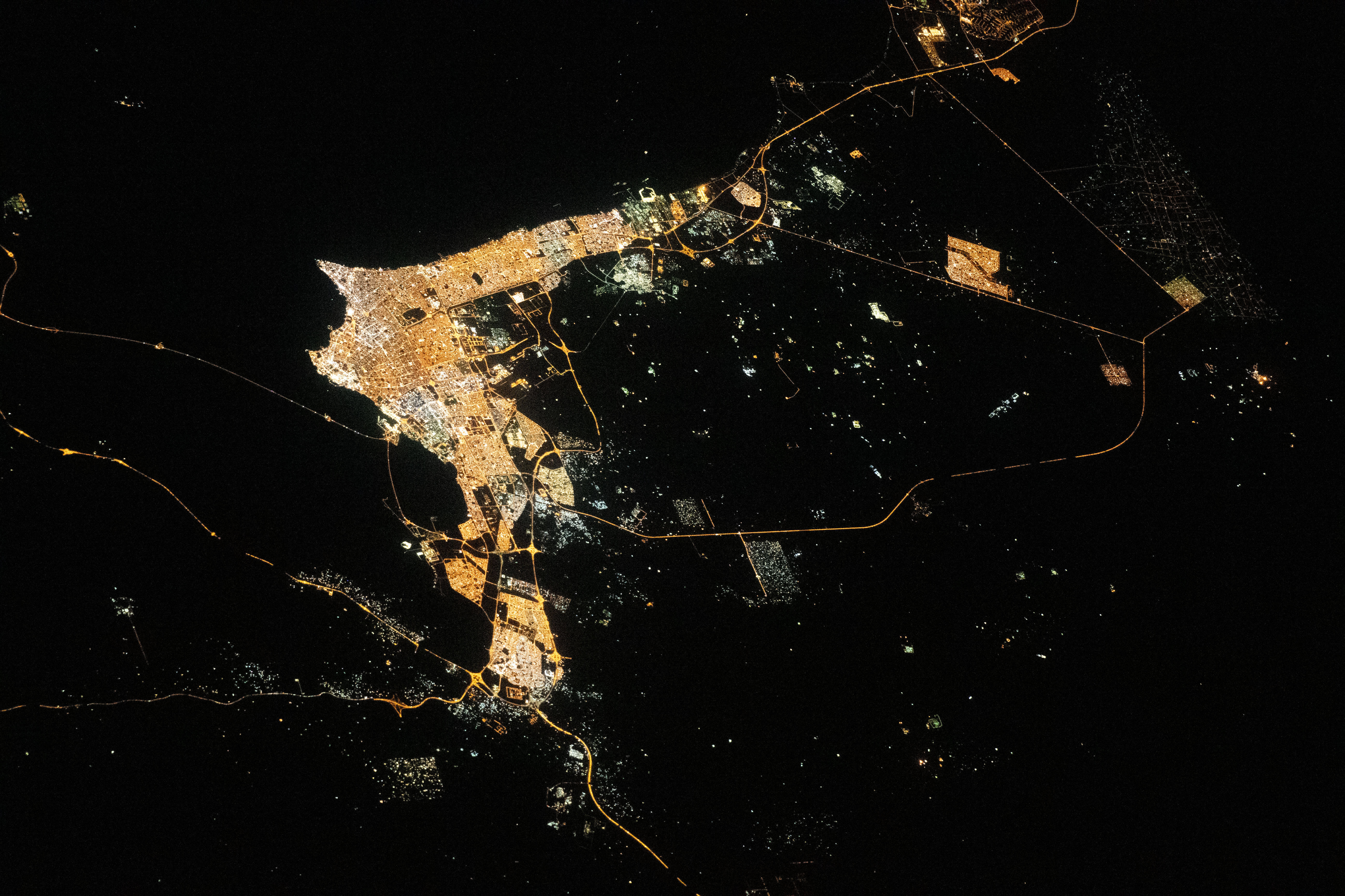 iss070e105657 (March 2, 2024) --- The city lights of Kuwait City, Kuwait, and its surrounding suburbs on the coast of Kuwait Bay and the Persian Gulf are pictured from the International Space Station as it orbited 261 miles above the Middle Eastern nation of Iraq.