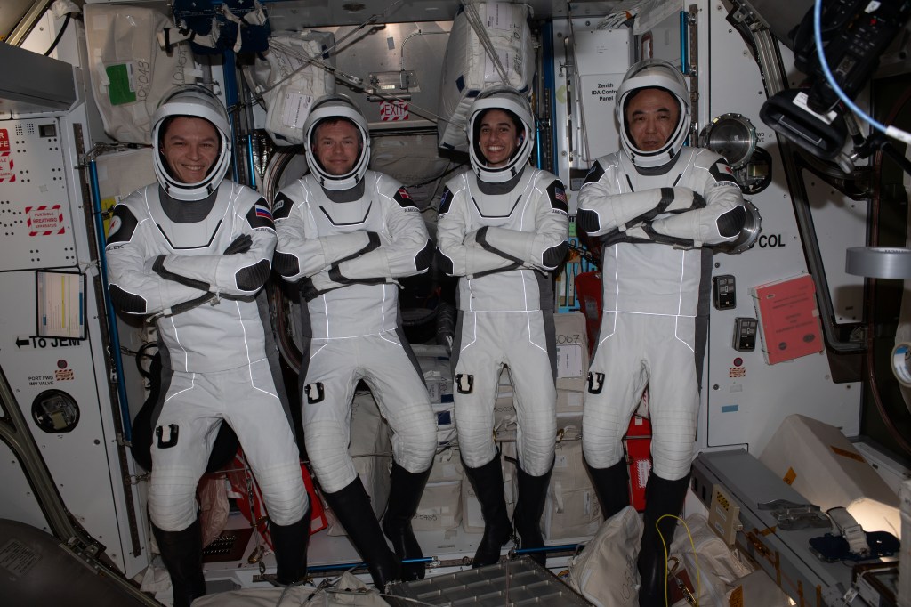 iss070e108296 (March 6, 2024) -- The Crew-7 quartet (from left), cosmonaut Konstantin Borisov, ESA (European Space Agency) astronaut Andreas Mogensen, NASA astronaut Jasmin Moghbeli, and JAXA (Japan Aerospace Exploration Agency) astronaut Satoshi Furukawa pose for a photo in their Dragon flight suits ahead of their departure from the International Space Station.