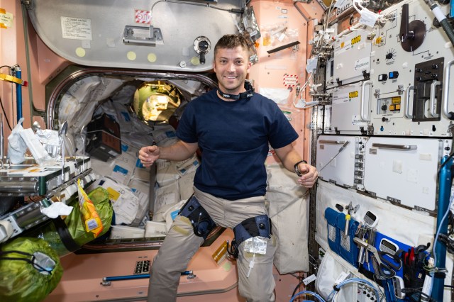 iss070e108772 (March 6, 2024) -- Expedition 70 Flight Engineer and NASA astronaut Matthew Dominick tests out pressure cuffs on his thighs, which will be used to examine whether wearing the cuffs in microgravity changes the way fluid moves around inside the body.