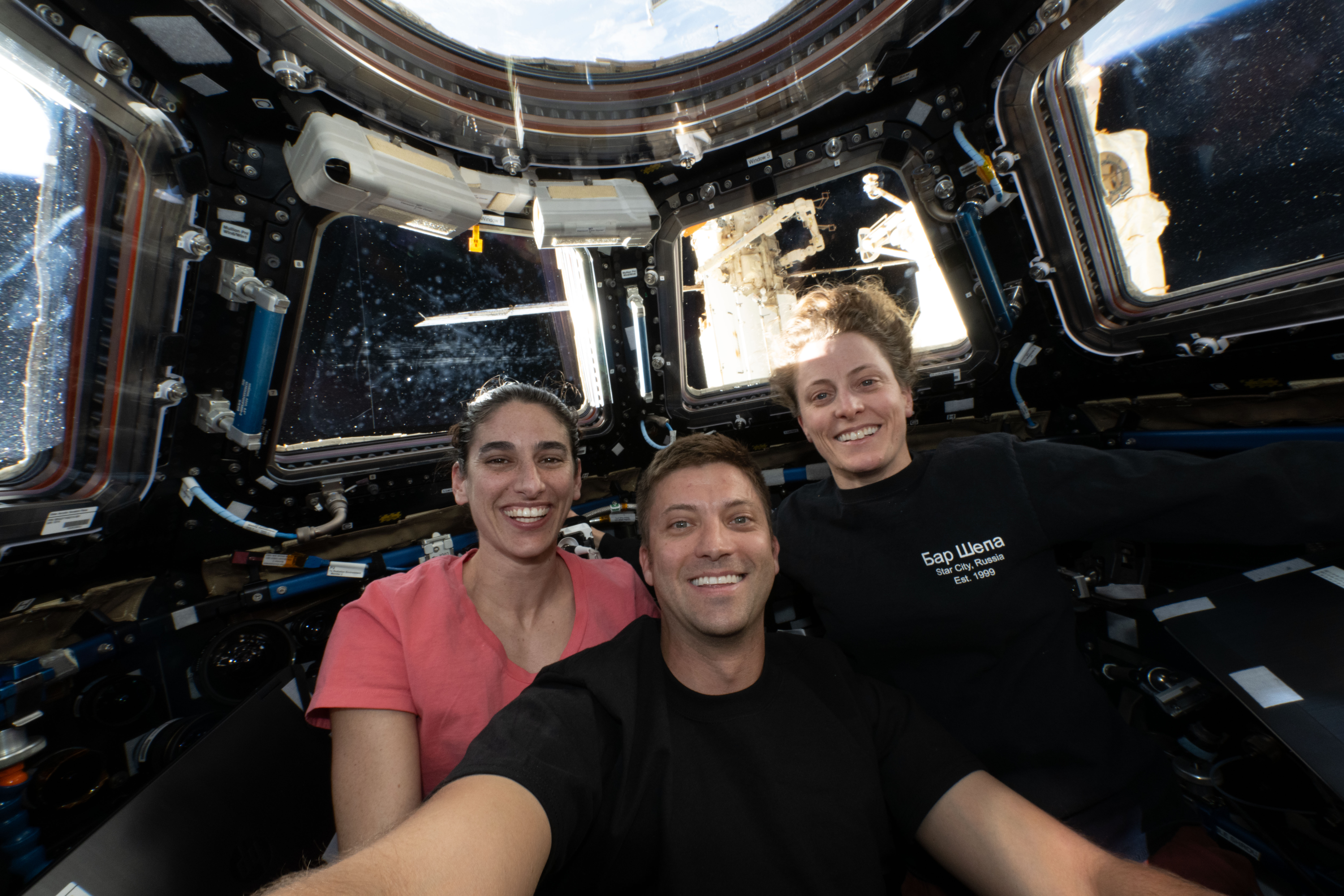 iss070e111212 (March 10, 2024) -- NASA astronauts (from left) Jasmin Moghbeli, Matthew Dominick, and Loral O'Hara pose for a selfie inside the International Space Station's cupola, or "window to the world."
