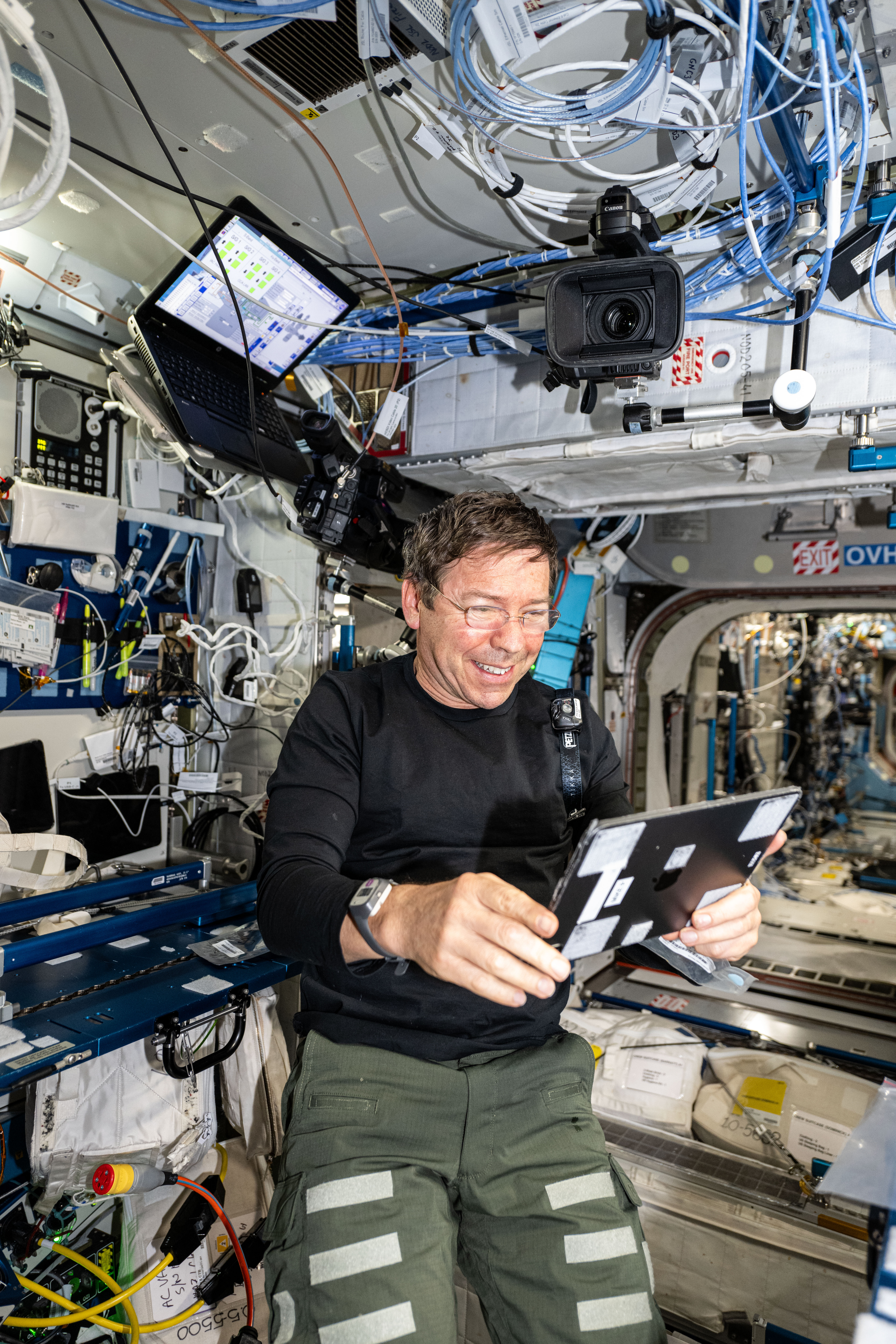 iss070e113283 (March 11, 2024) -- NASA astronaut and Expedition 70 Flight Engineer Michael Barratt uses an iPad to review the on-orbit schedule for residents aboard the International Space Station.