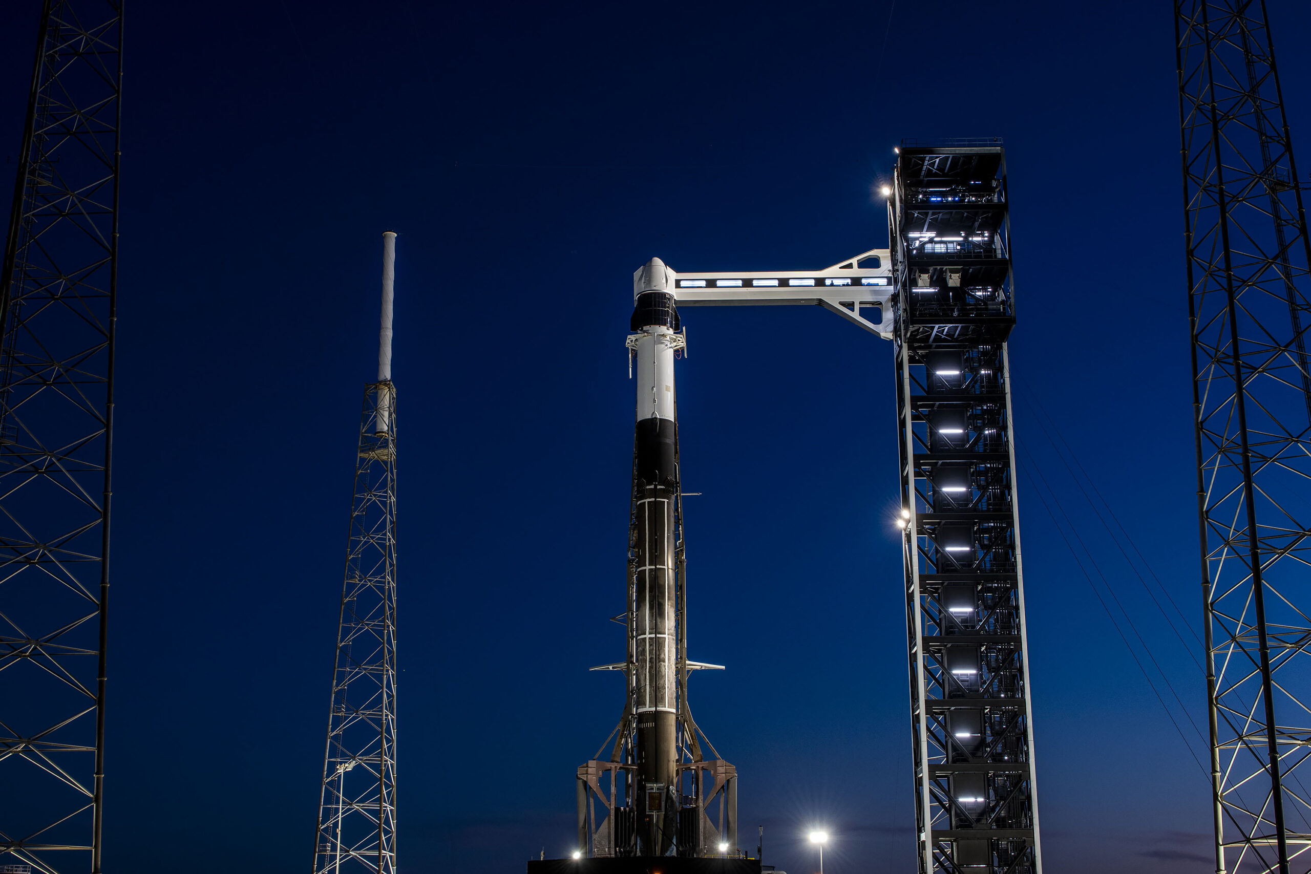 SpaceX Falcon 9 rocket and Dragon spacecraft on Space Launch Complex 40 at night