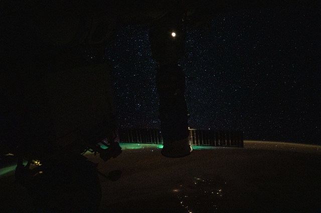 iss060e002056 (June 29, 2019) --- Flying 268 miles above New Zealand, the International Space Station's docked Progress 72 resupply ship is silhouetted over a wispy aurora australis, or "southern lights," the Earth's atmospheric glow and a starry orbital nighttime sky. The bright light at top is the Pirs module's lit airlock window.