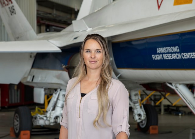 Portrait of a woman standing in front of an airplane.