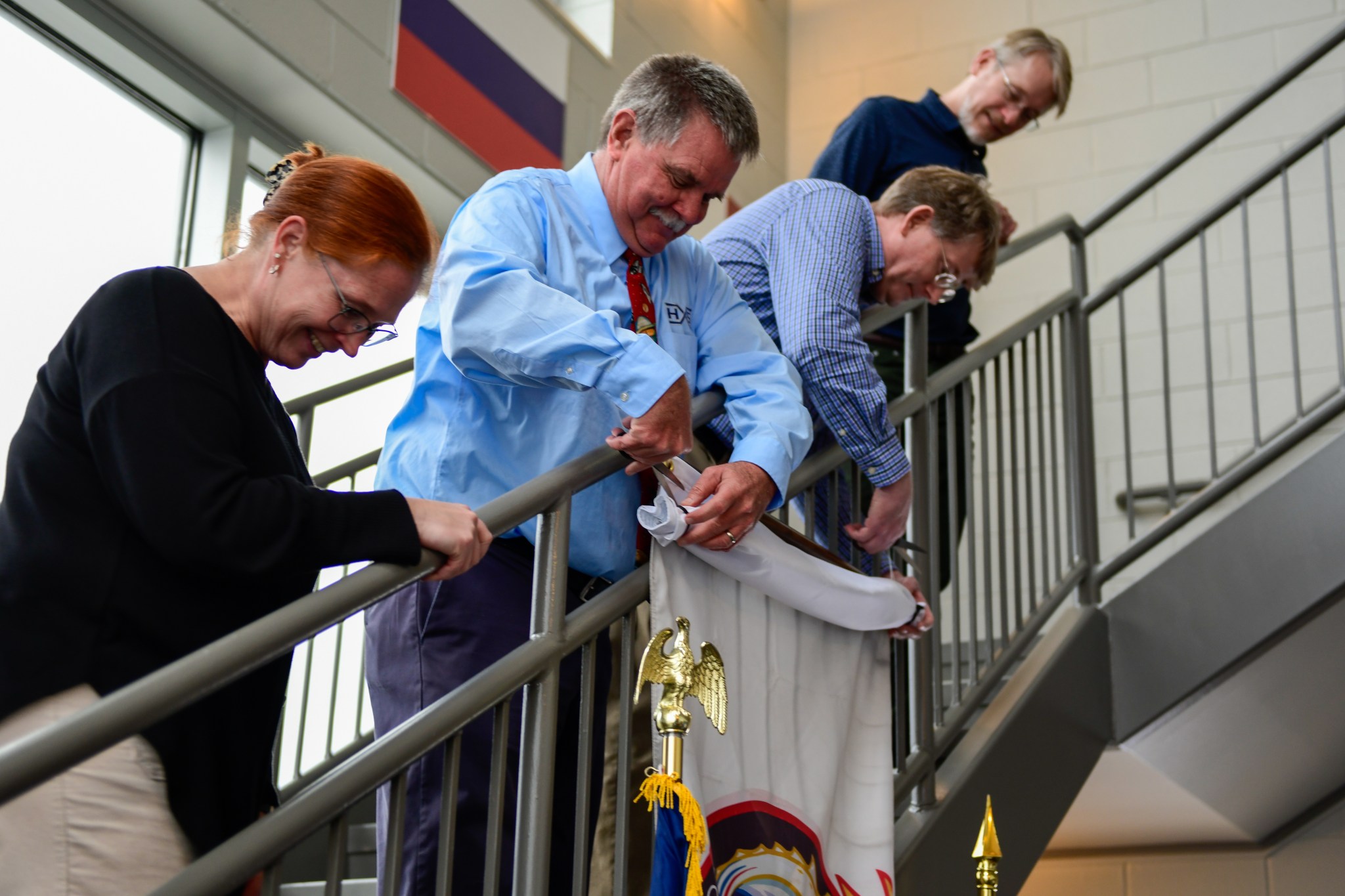 From left, Nicole Pelfrey, manager of Payload and Mission Operations Division; Rick Oelkers, ground systems operations team lead; Eric Earhart, rotordynamics lead; and Dave Gwaltney, technical assistant for the Commercial Crew Program’s Launch Vehicle Systems Office special systems, stand on the staircase as Oelkers and Earhart prepare to unveil the Crew-8 mission flag.