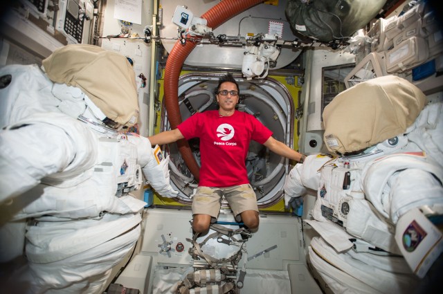 Astronaut Joe Acaba poses between two U.S. spacesuits inside the Quest airlock. He will wear one of those spacesuits on a spacewalk scheduled for Oct. 20, 2017. Joining Acaba on the spacewalk Friday morning will be Commander Randy Bresnik