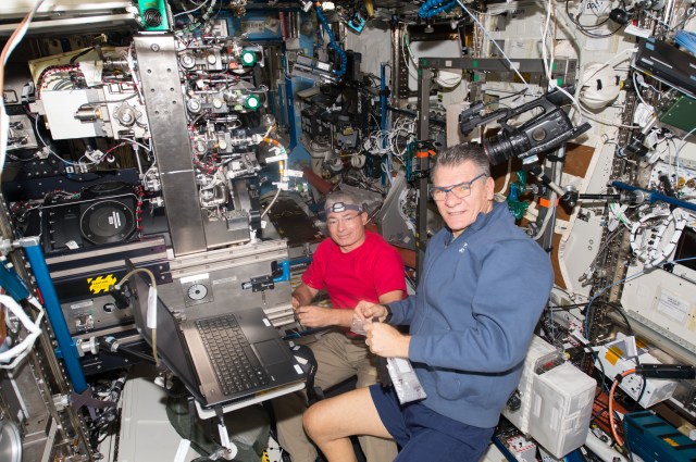 Astronauts Mark Vande Hei (left) and Paolo Nespoli work on the Combustion Integrated Rack (CIR) inside the Destiny laboratory module.