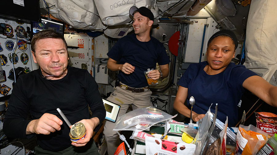 NASA astronauts (from left) Mike Barratt, Matthew Dominick, and Jeanette Epps enjoy breakfast inside the International Space Station's Unity Module.