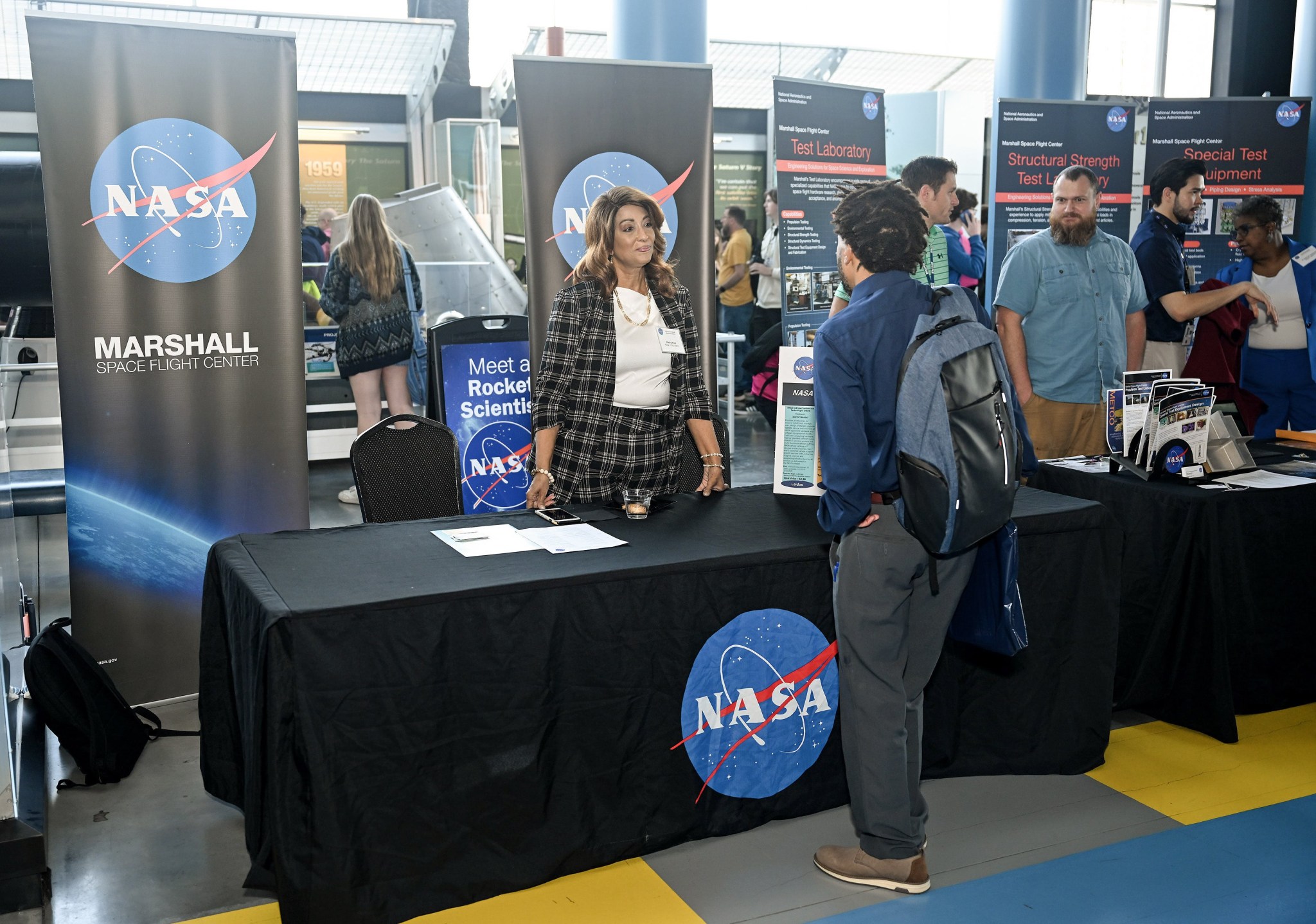 Kathy Rice, center, an information technology specialist at Marshall, talks with an attendee about the center’s small business capabilities.