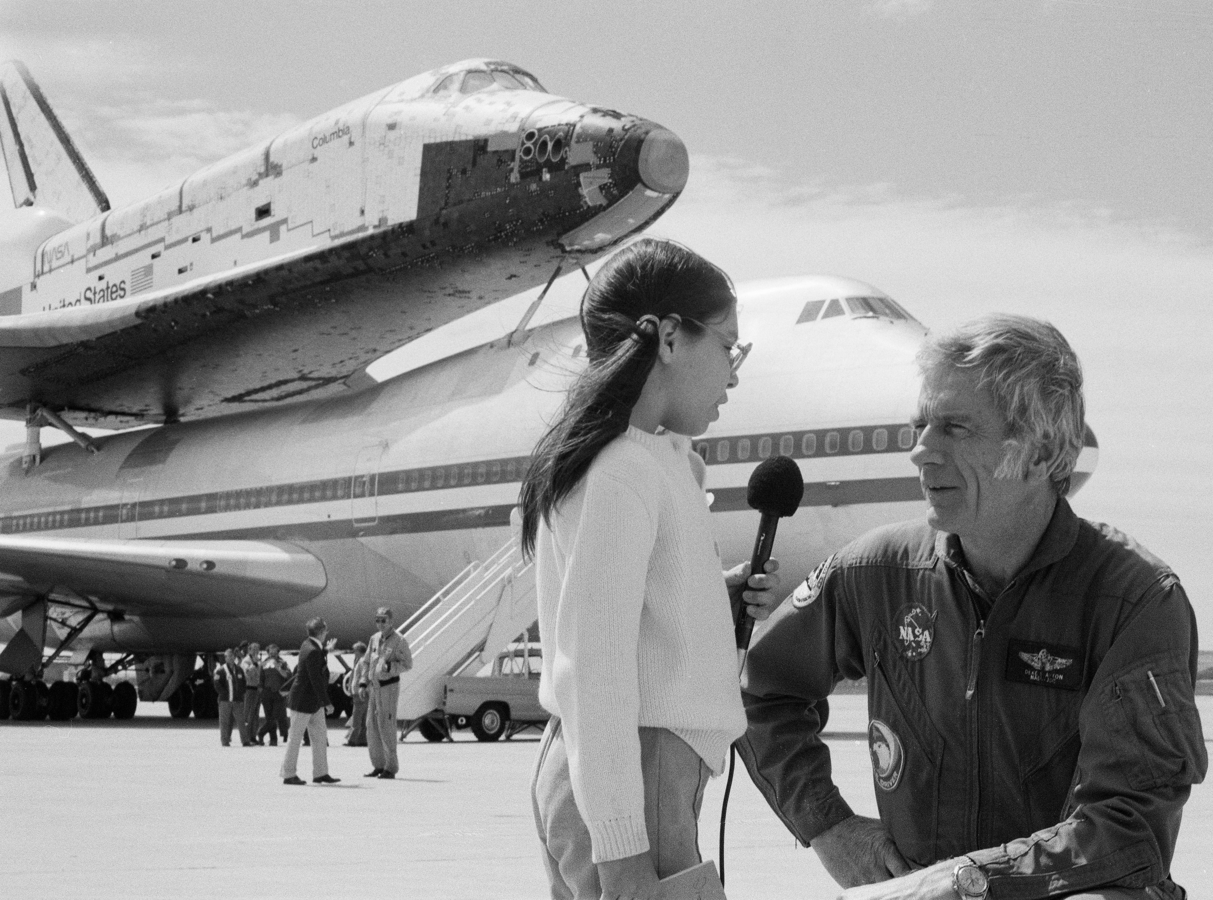 Tina Aguilar, age nine, an aspiring young reporter, interviews astronaut Donald K. “Deke” Slayton in front of Columbia and the SCA at Kelly AFB