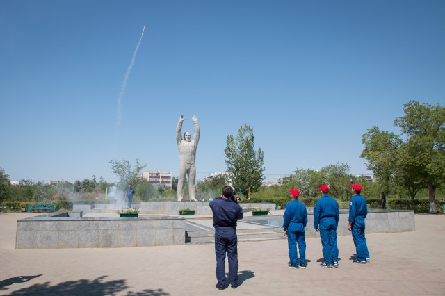 Expedition 52-53 backup crewmembers Mark Vande Hei of NASA (left), Alexander Misurkin of the Russian Federal Space Agency (Roscosmos, center) and Norishige Kanai of the Japan Aerospace Exploration Agency (JAXA, right) watch as an amateur rocket takes flight by the statue of Yuri Gagarin, the first human in space, in the town of Baikonur, Kazakhstan July 18 during traditional pre-launch ceremonies. They are serving as backups to Randy Bresnik of NASA, Sergey Ryazanskiy of Roscosmos and Paolo Nespoli of the European Space Agency, who will launch July 28 on the Soyuz MS-05 spacecraft from the Baikonur Cosmodrome for a five-month mission on the International Space Station.