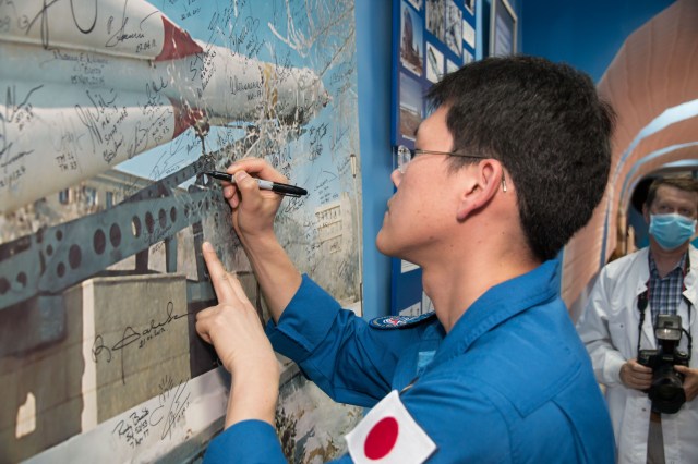Expedition 52-53 backup crewmember Norishige Kanai of the Japan Aerospace Exploration Agency (JAXA) signs a mural in a space museum in Baikonur, Kazakhstan July 18 during traditional pre-launch ceremonies. Kanai, Alexander Misurkin of the Russian Federal Space Agency (Roscosmos) and Mark Vande Hei of NASA are serving as backups to Sergey Ryazanskiy of Roscosmos, Randy Bresnik of NASA and Paolo Nespoli of the European Space Agency, who will launch July 28 on the Soyuz MS-05 spacecraft from the Baikonur Cosmodrome for a five-month mission on the International Space Station.