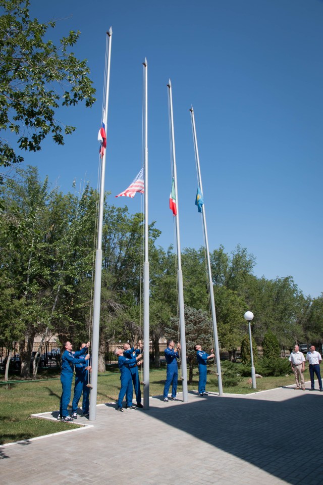 At the Cosmonaut Hotel crew quarters in Baikonur, Kazakhstan, the Expedition 52-53 prime and backup crewmembers raised the flags of the U.S., Russia, Italy and Kazakhstan July 18 during traditional pre-launch ceremonies. From left to right are Sergey Ryazanskiy and Alexander Misurkin of the Russian Federal Space Agency (Roscosmos) raising the Russian flag, Mark Vande Hei and Randy Bresnik of NASA raising the U.S. flag, Paolo Nespoli of the European Space Agency raising the flag of Italy and Norishige Kanai of the Japan Aerospace Exploration Agency (JAXA) raising the flag of Kazakhstan. Ryazanskiy, Bresnik and Nespoli will launch July 28 on the Soyuz MS-05 spacecraft from the Baikonur Cosmodrome for a five-month mission on the International Space Station.