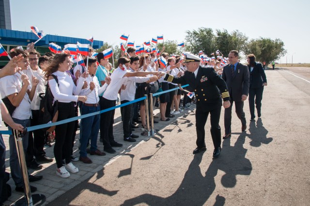 Expedition 53-54 backup crewmembers Scott Tingle of NASA (foreground), Anton Shkaplerov of Roscosmos (center), and Shannon Walker of NASA are greeted by local students after arriving at the launch site at the Baikonur Cosmodrome in Kazakhstan Sept. 6 after a flight from their training base in Star City, Russia for final pre-launch training. They are serving as backups to the prime crew, Alexander Misurkin of Roscosmos and Joe Acaba and Mark Vande Hei of NASA, who will launch Sept. 13 on the Soyuz MS-06 spacecraft from the Baikonur Cosmodrome for a five and a half month mission on the International Space Station.