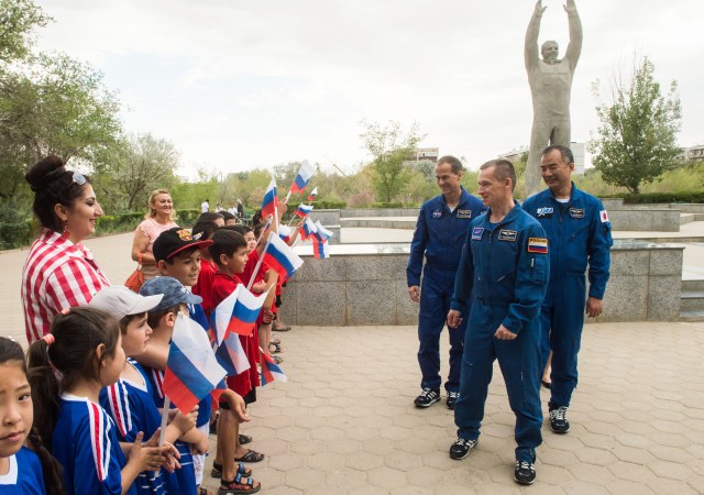jsc2019e038392 (July 6, 2019) --- In the town of Baikonur, Kazakhstan, Expedition 60 backup crewmembers Tom Marshburn of NASA (left), Sergey Ryzhikov of Roscosmos (center) and Soichi Noguchi of the Japan Aerospace Exploration Agency (right) greet local school children July 6 near the statue of Yuri Gagarin, the first human to fly in space, during traditional pre-launch activities. They are the backups to Drew Morgan of NASA, Luca Parmitano of the European Space Agency and Alexander Skvortsov of Roscosmos, who will launch July 20 on the Soyuz MS-13 spacecraft from the Baikonur Cosmodrome in Kazakhstan for a mission on the International Space Station. Credit: Andrey Shelepin/GCTC