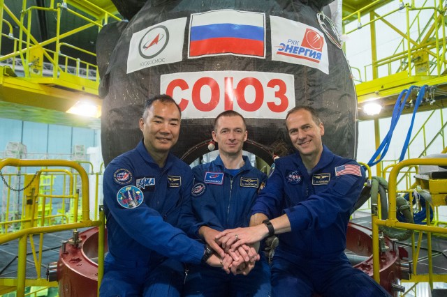 jsc2019e038388 (July 5, 2019) --- At the Baikonur Cosmodrome in Kazakhstan, Expedition 60 backup crewmembers Soichi Noguchi of the Japan Aerospace Exploration Agency (left), Sergey Ryzhikov of Roscosmos (center) and Tom Marshburn of NASA (right) pose for pictures July 5 in front of the Soyuz MS-13 spacecraft during pre-launch preparations. They are the backups to Drew Morgan of NASA, Alexander Skvortsov of Roscosmos and Luca Parmitano of the European Space Agency, who will launch July 20 on the Soyuz MS-13 spacecraft from the Baikonur Cosmodrome for a mission on the International Space Station. Credit: Andrey Shelepin/GCTC