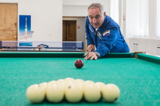 jsc2019e039268 (July 12, 2019) --- At the Cosmonaut Hotel crew quarters in Baikonur, Kazakhstan, Expedition 60 crewmember Alexander Skvortsov of Roscosmos tries his hand at billiards July 12 as part of pre-launch activities. Skvortsov, Drew Morgan of NASA and Luca Parmitano of the European Space Agency will launch July 20 on the Soyuz MS-13 spacecraft from the Baikonur Cosmodrome in Kazakhstan on a mission to the International Space Station. Credit: Andrey Shelepin/GCTC