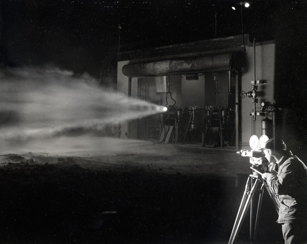 Man film horizontal rocket firing at night.