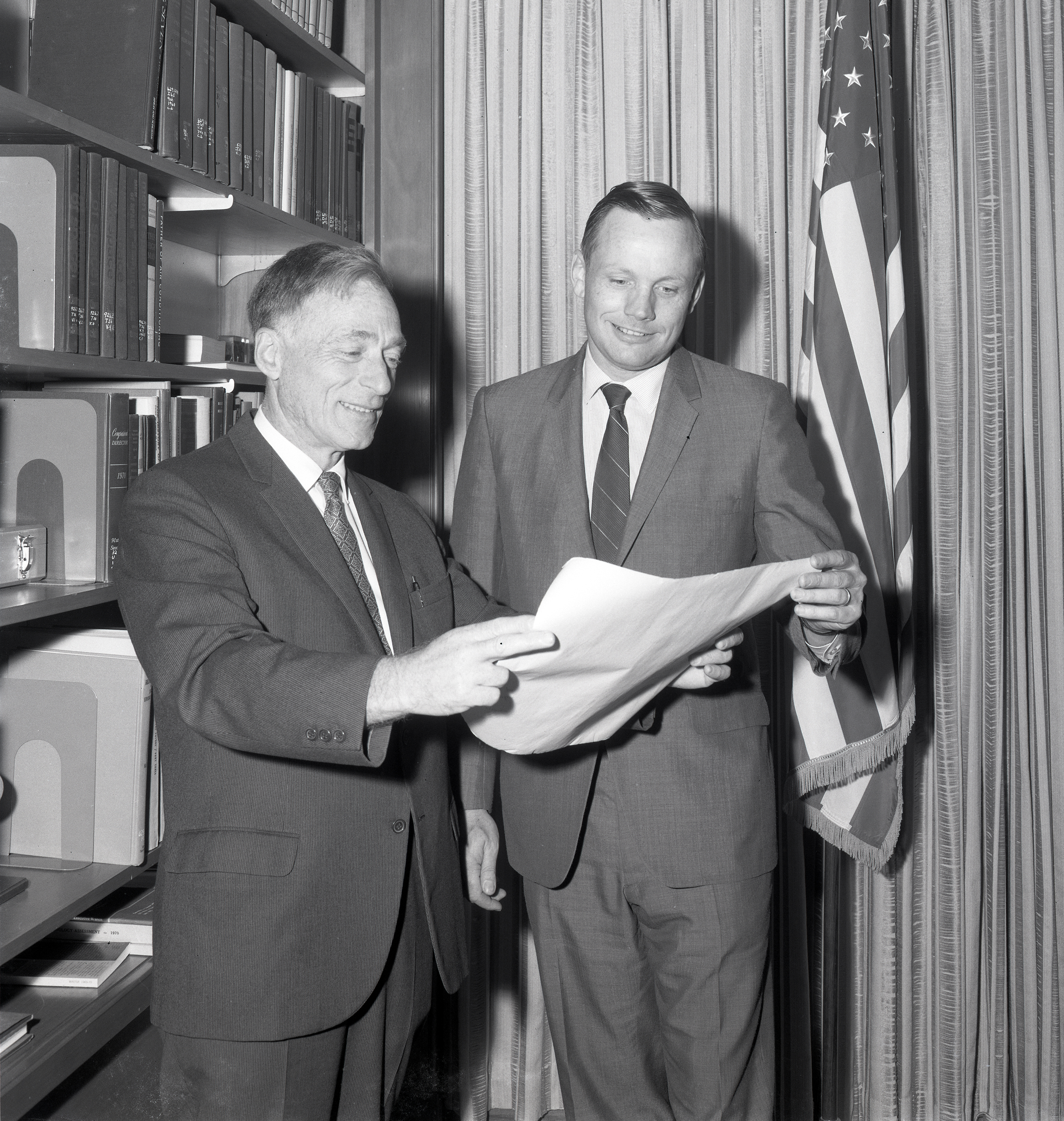 Two men examining document.
