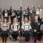 Group of people posing for photograph with plaques.