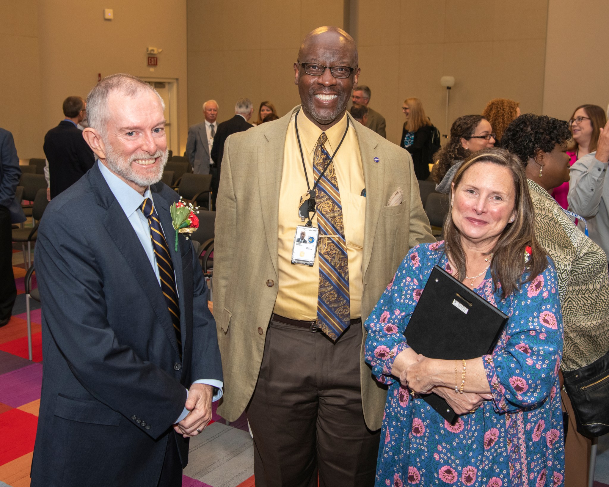 Two men and woman standing together.