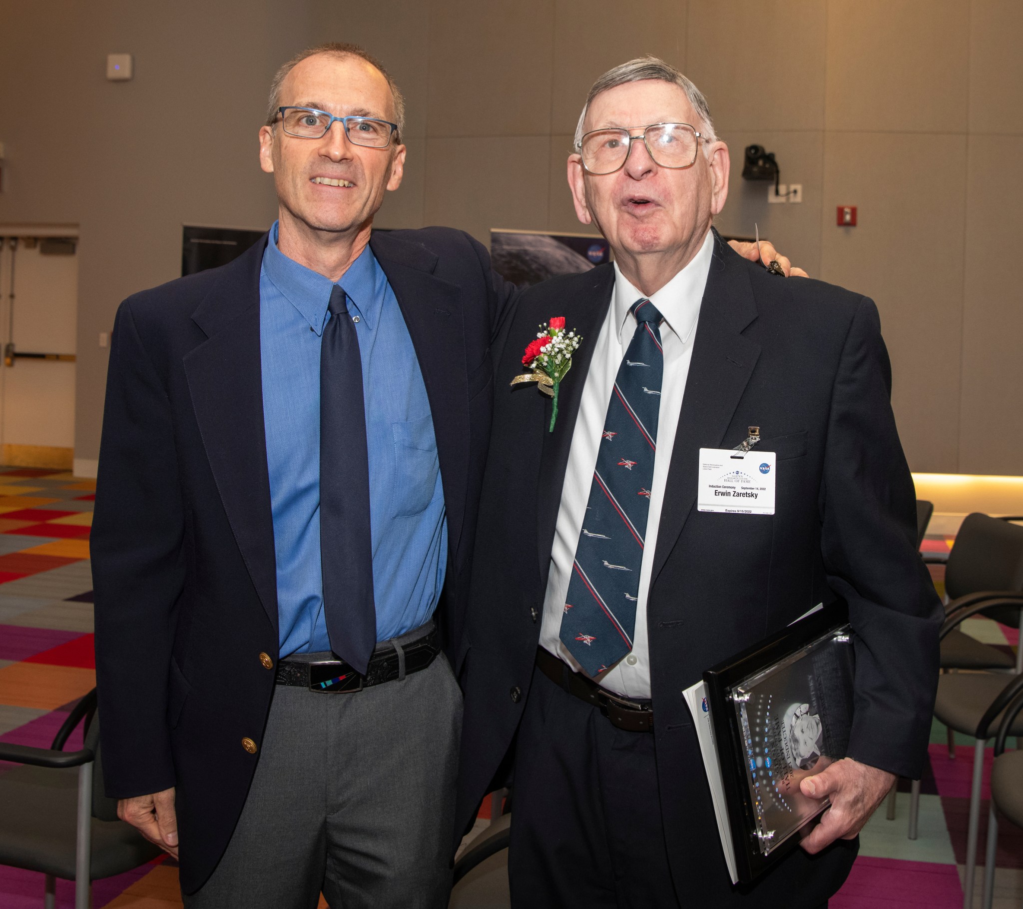 Two men standing next to one another.