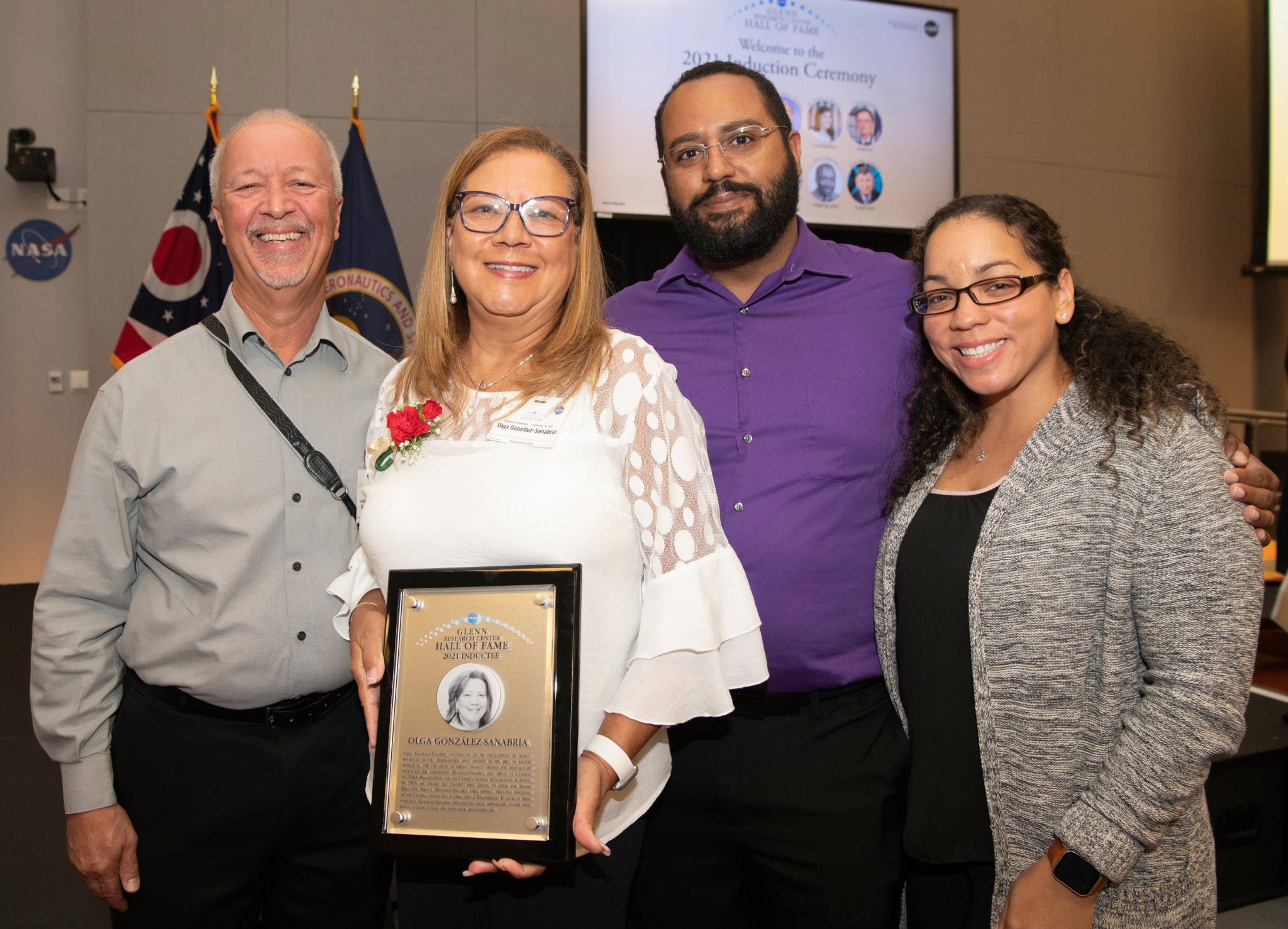 Two men and two woman posing with plaque.