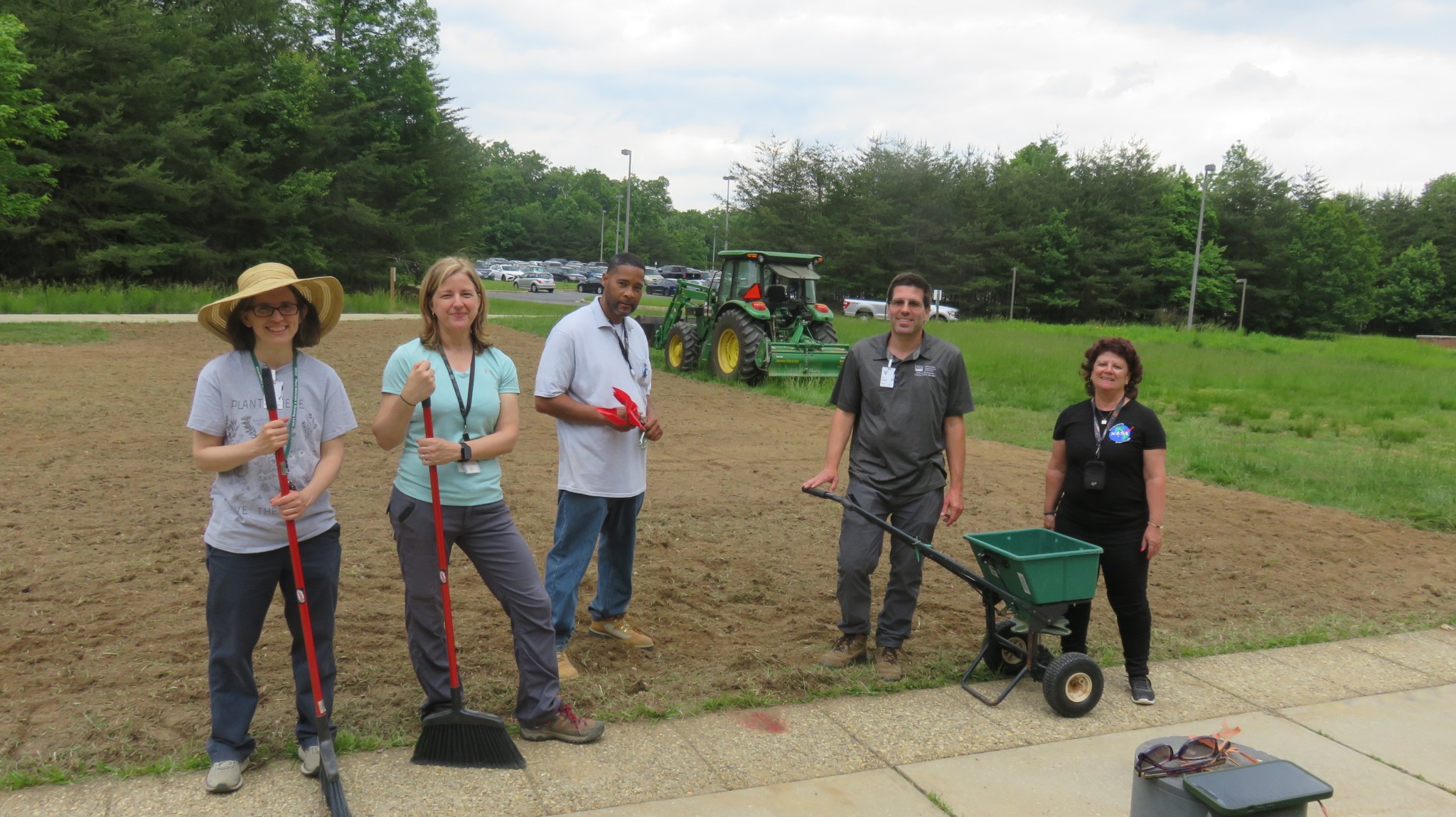 People standing in front of an area that was just tilled.