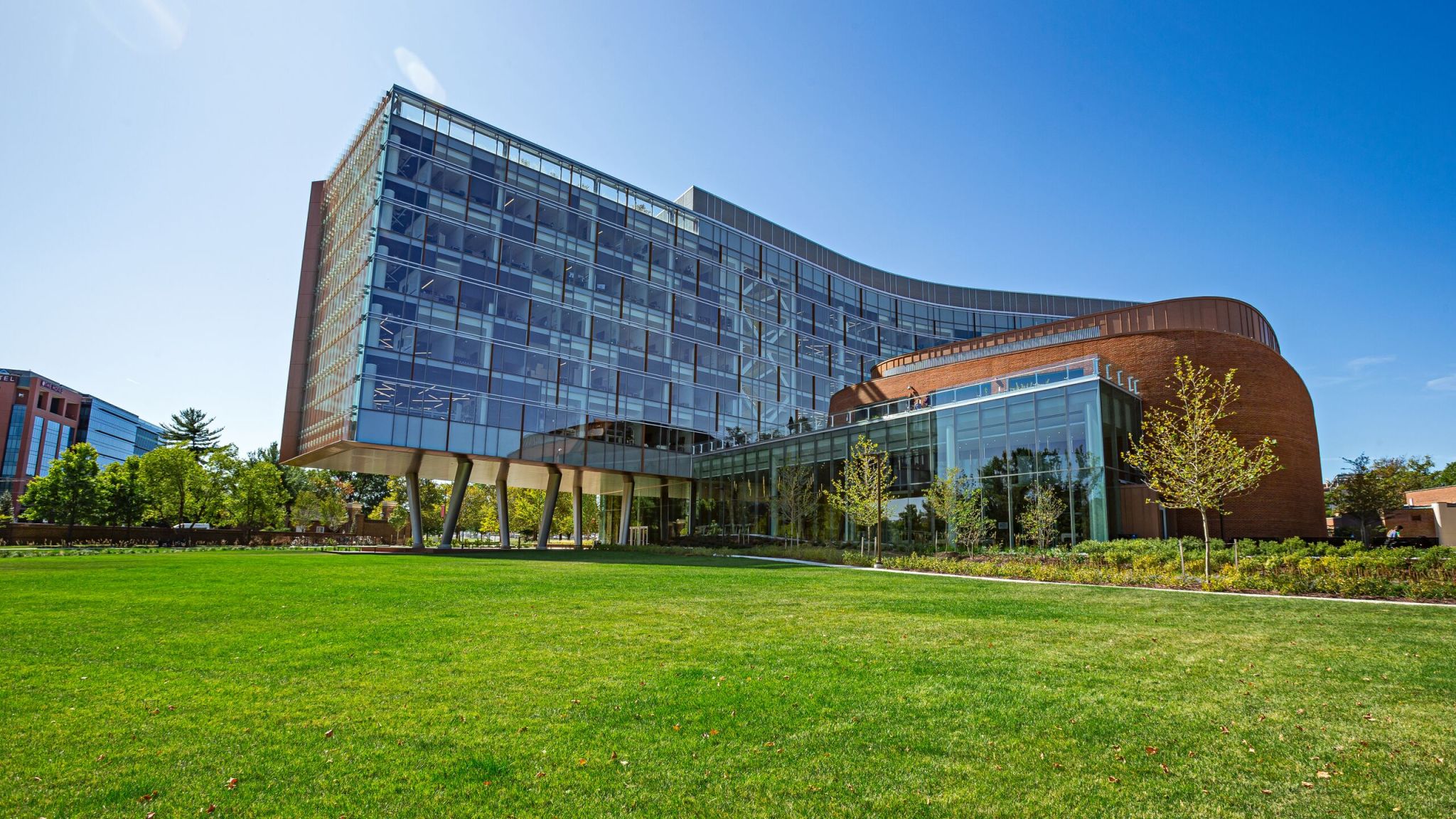 Brendan Iribe Center, a multi-story building made up of mostly glass windows on a bright green lawn.