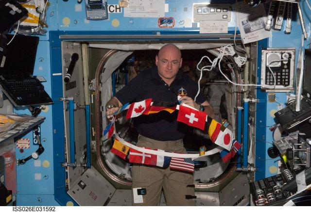 ISS026-E-031592 (3 March 2011) --- NASA astronaut Scott Kelly, Expedition 26 commander, works with the flags of the international partners onboard the U.S. lab Destiny on the International Space Station.