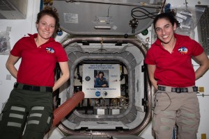 Expedition 70 Flight Engineers (from left) Loral O'Hara and Jasmin Moghbeli pose for a photograph in front of the Unity module's port that leads into the Northrop Grumman Cygnus space freighter, named the S.S. Patricia "Patty" Hilliard Robertson. Inside Cygnus is a poster of Robertson, a former NASA astronaut, for whom the Cygnus resupply ship is named after.