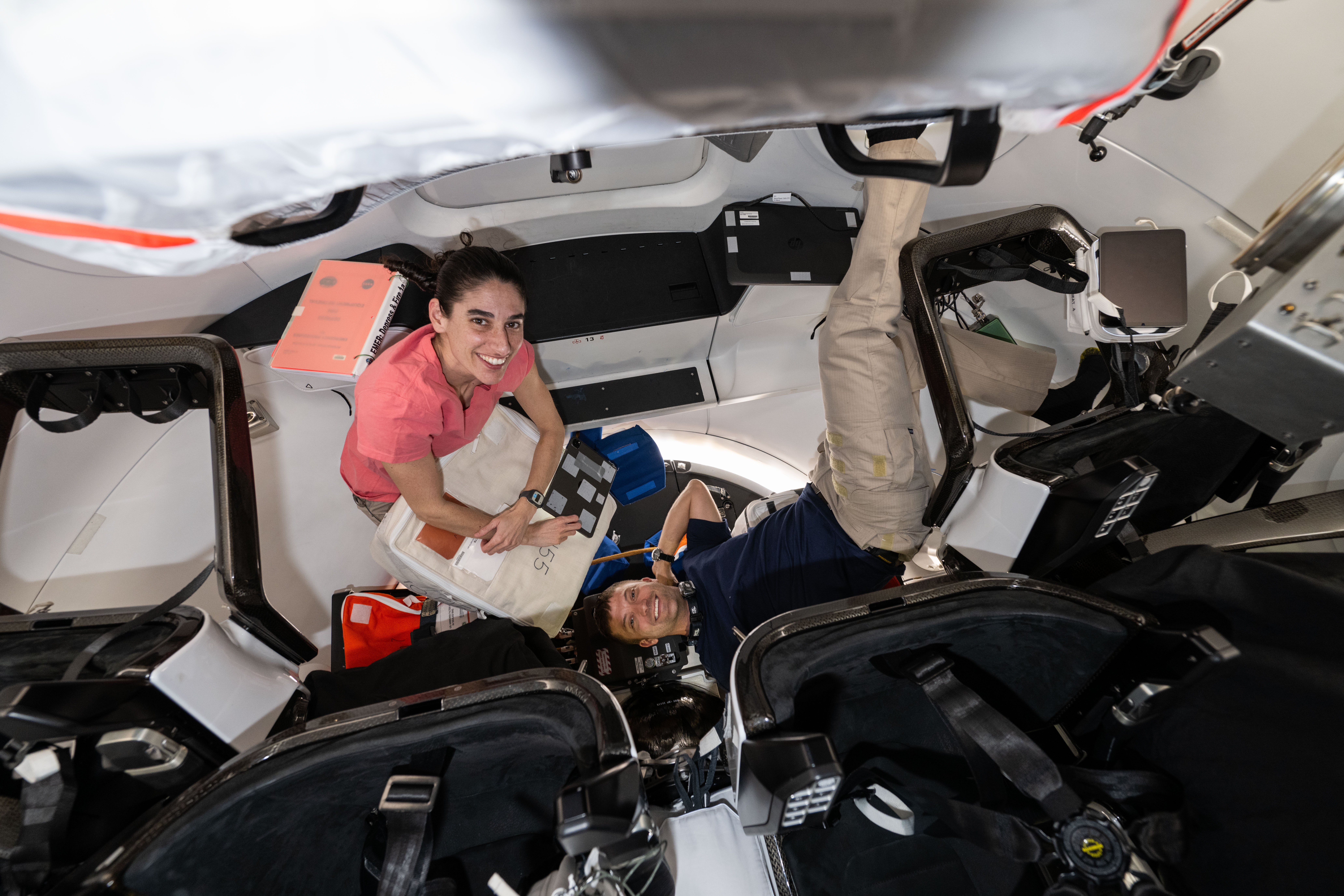 Expedition 70 Flight Engineers Jasmin Moghbeli and Matthew Dominick, both NASA astronauts, work inside a SpaceX Dragon crew spaceraft transferring emergency equipment from the International Space Station into the commercial crew vehicle.