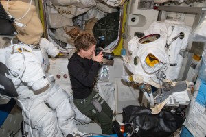Expedition 70 Flight Engineer and NASA astronaut Loral O'Hara photographs the condition of spacesuits during maintenance inside the International Space Station's Quest airlock.