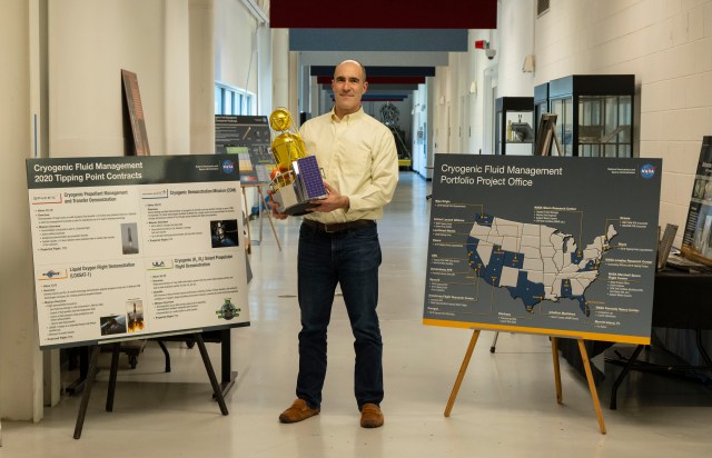 A man stands in in the middle of two poster boards on stands