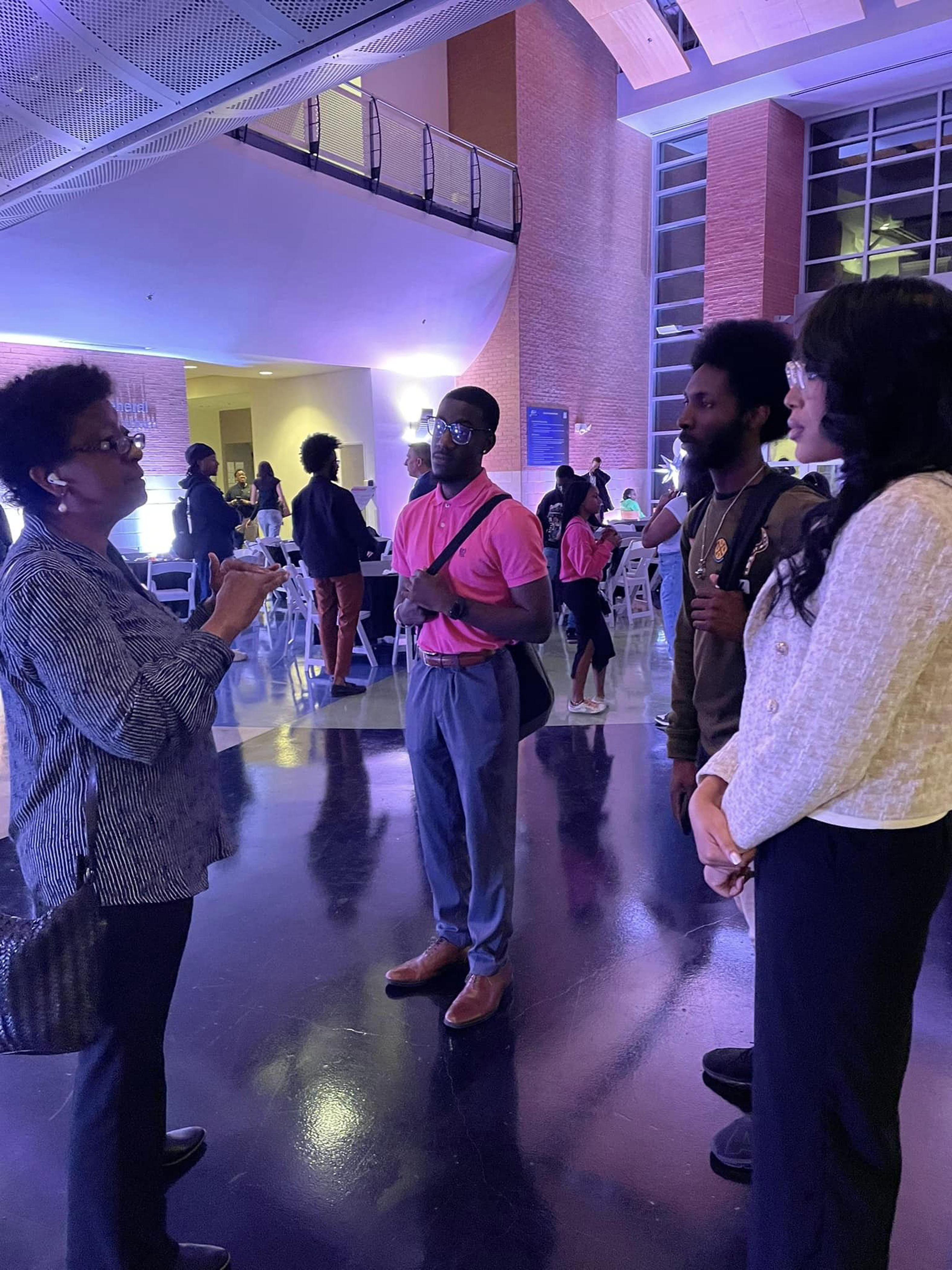 group of 3 students engaging with NASA Stennis representative