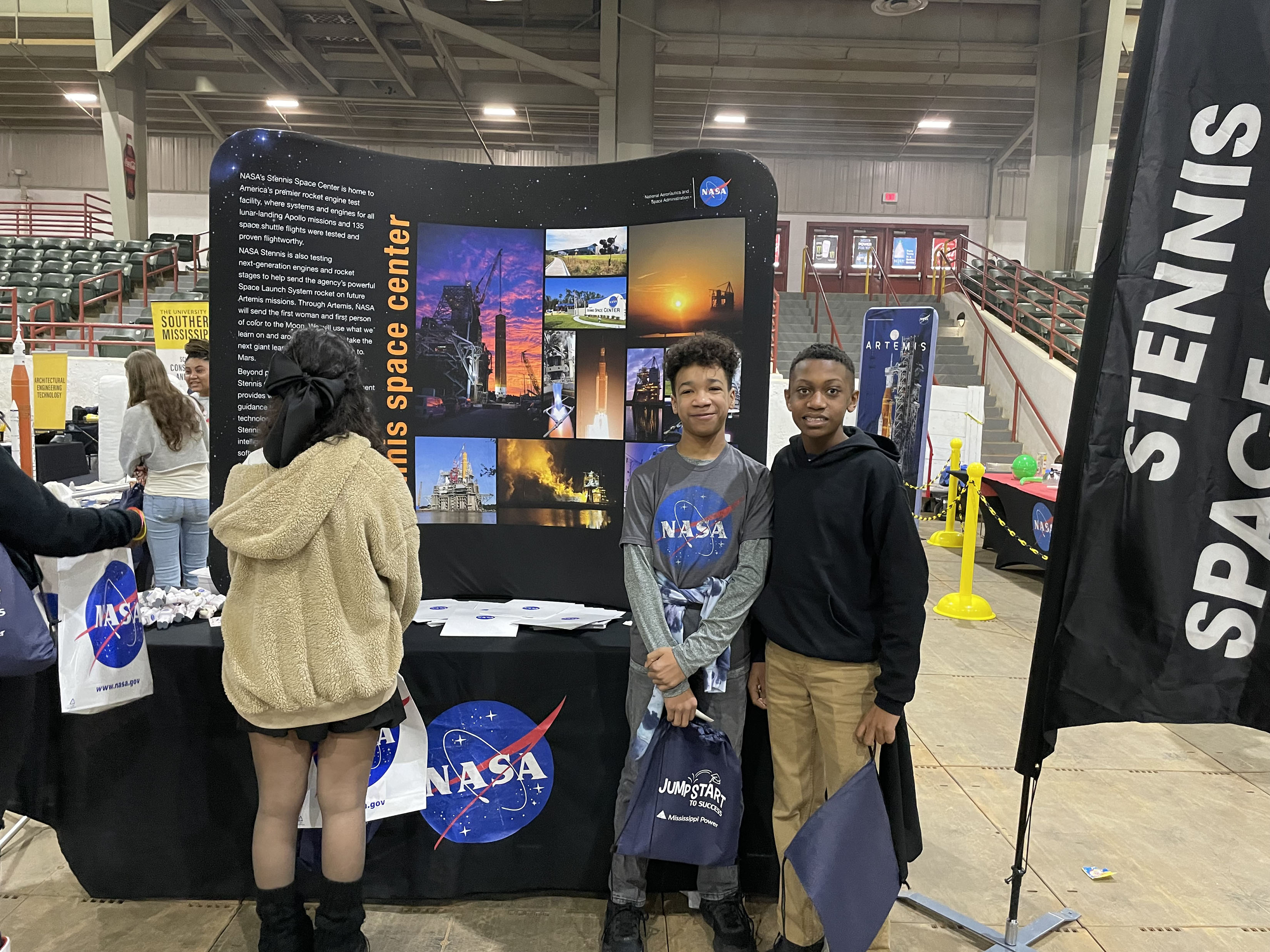 Three students pose in front of display at the Jumpstart to Success event